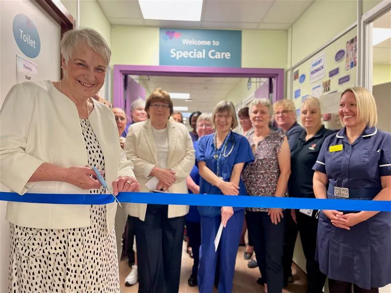 Anne-Marie Hamilton, previous Dreamdrops charity chair, cutting the blue ribbon during the official open with SCBU staff and charity representatives.