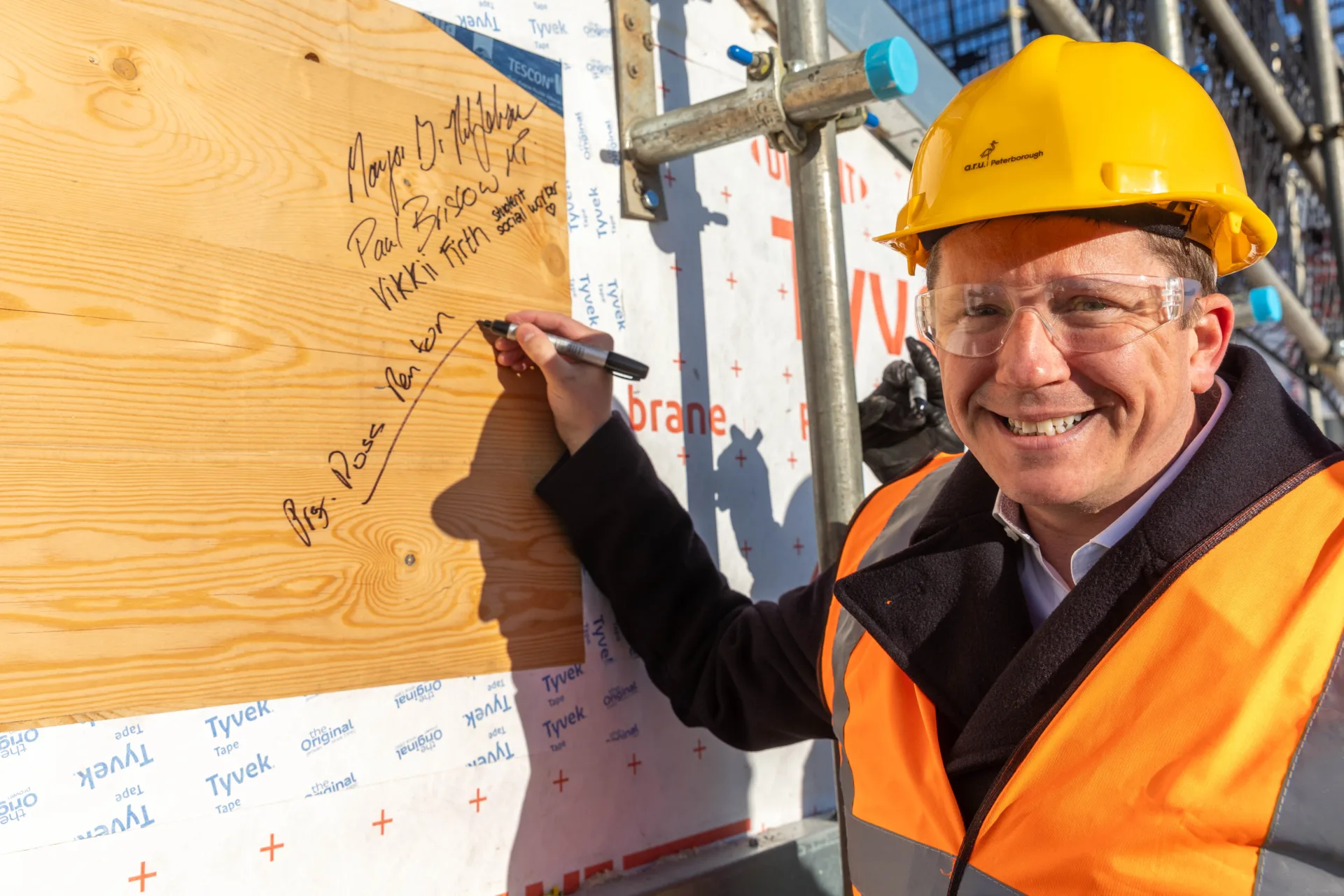 Anglian Ruskin University topping out ceremony for an extension to the Peterborough campus that will incorporate a ‘Living Lab’ public science and technology space. It will open in September. Principal Professor Ross Renton signs one of the roof panels. PHOTO: Terry Harris.