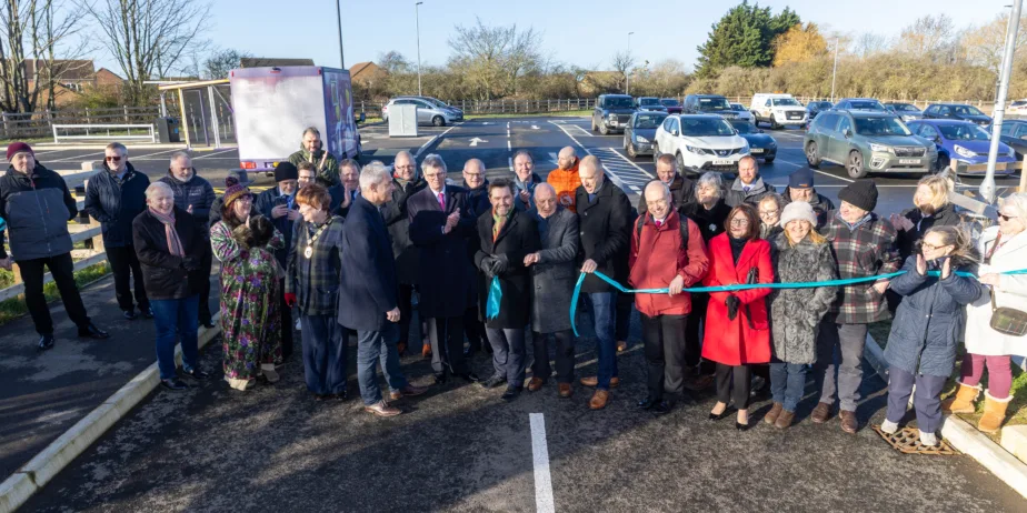 Ribbon-cutting celebration time: Getting ready to officially open Manea Station car park is Dr Nik Johnson, Mayor of Cambridgeshire & Peterborough (centre), with local MP Steve Barclay; Cllr Chris Seaton, Fenland District Council’s Cabinet member for transport and Chairman of the Hereward Community Rail Partnership; Steve Emery, former parish councillor and Hereward Community Rail Partnership board member; Cllr Ben Bonos, Chairman of Manea Parish Council; Jonathan Denby, Head of Corporate Affairs for Greater Anglia; and other partners, board members and representatives involved in bringing the project to fruition.