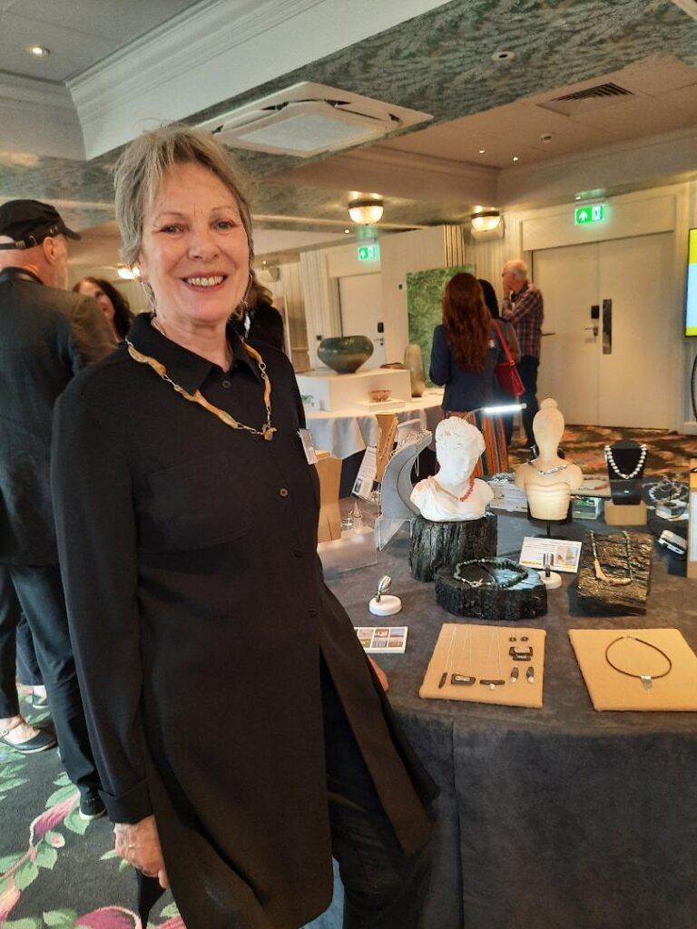 Carol Banks wearing her jewellery created with driftwood and the leaves of flowers