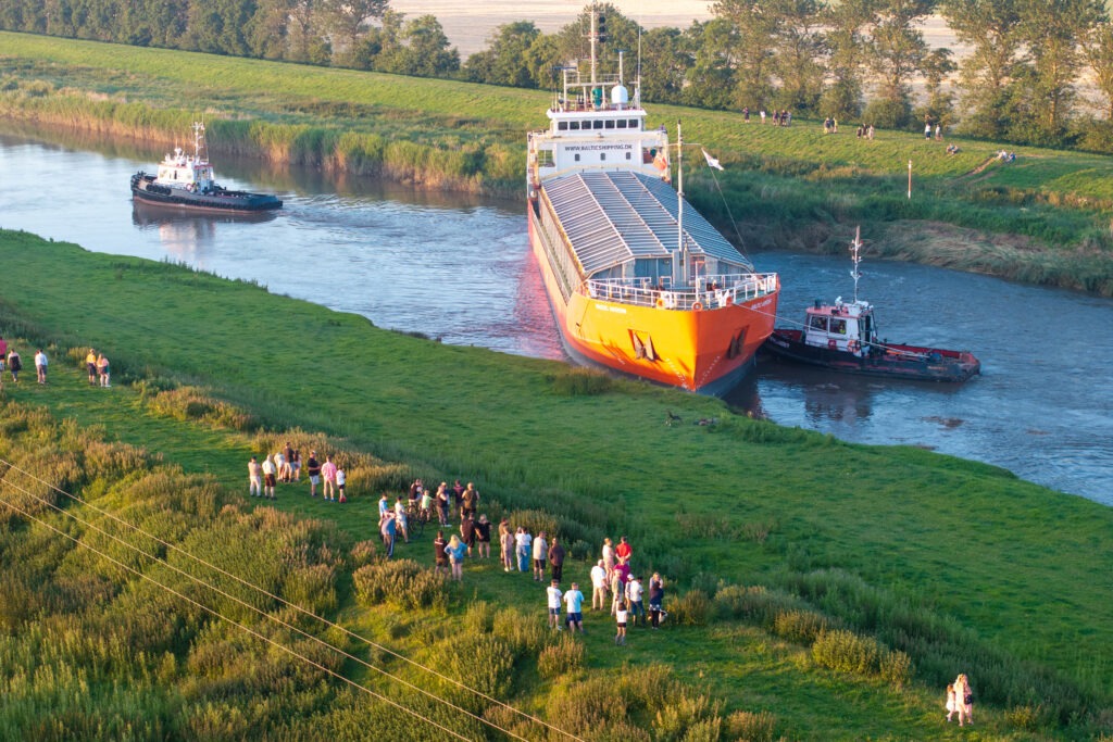 Spectators gathered by the River Nene in Wisbech as the Baltic Arrow, with its cargo of timber from Latvia, was finally freed and pulled into port. PHOTO: Terry Harris 