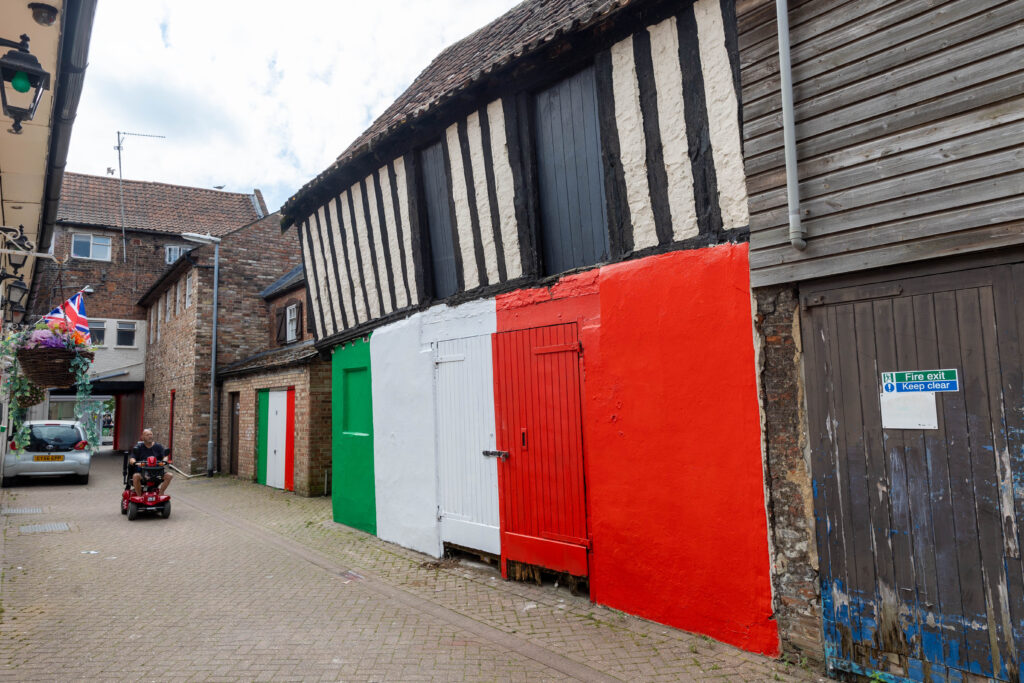 Wisbech town councillor Shahid Rafique facing an outcry after he painted a 15th century listed building red, white and green – to match the colours of his Italian Affairs restaurant 