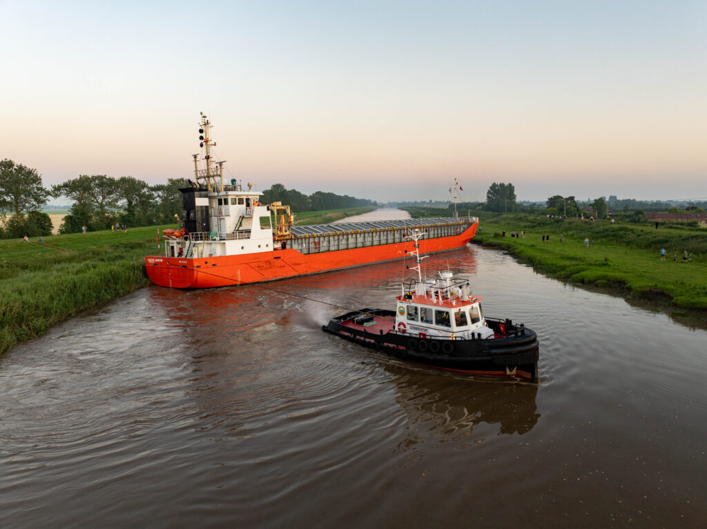 Spectators gathered by the River Nene in Wisbech as the Baltic Arrow, with its cargo of timber from Latvia, was finally freed and pulled into port. PHOTO: Terry Harris 