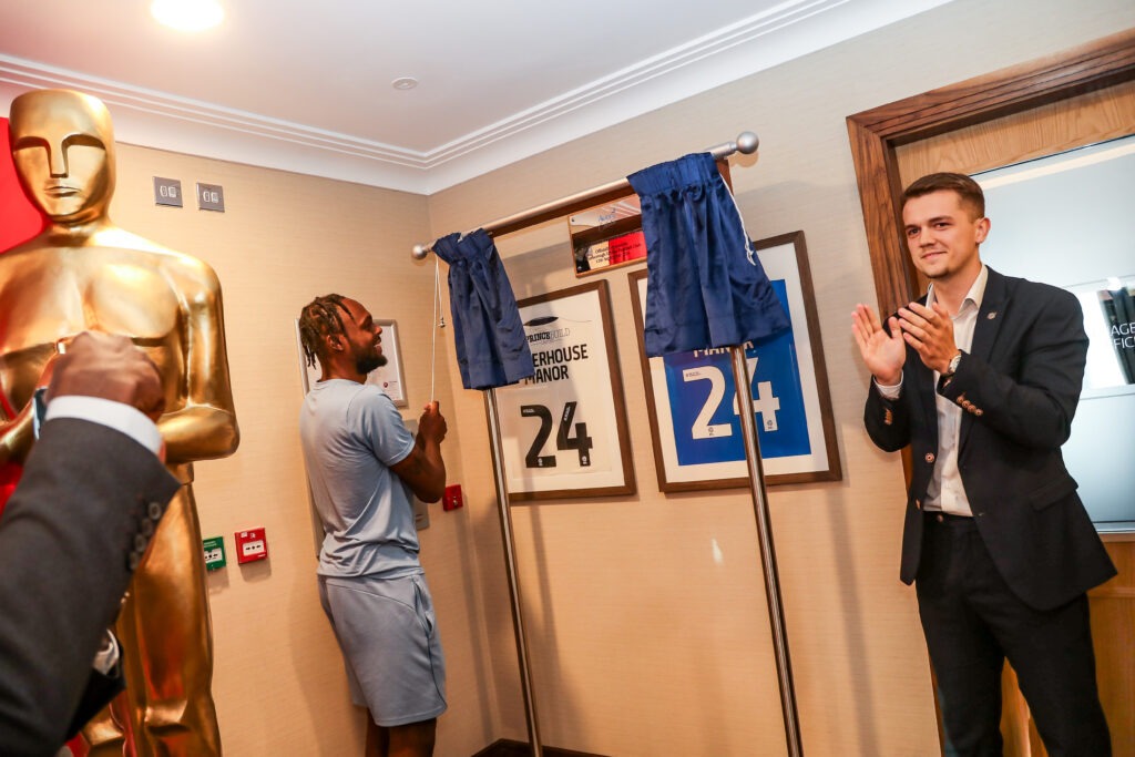 (L-R): Ricky-Jade Jones, Striker for Peterborough United FC, unveiling the plaque at Waterhouse Manor Care Home, with Bobby Copping, Commercial Sales Manager at Peterborough United.