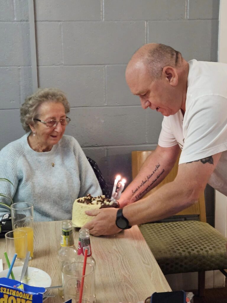 Lions night and Avis is presented with a birthday cake by Andy Maul 