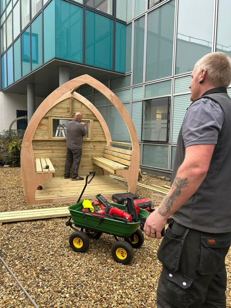 Jennie Grainger – Lead Volunteer Gardener and Staff Reflection Garden designer – with some of the Wood Wizards team installing the pods at Peterborough City Hospital