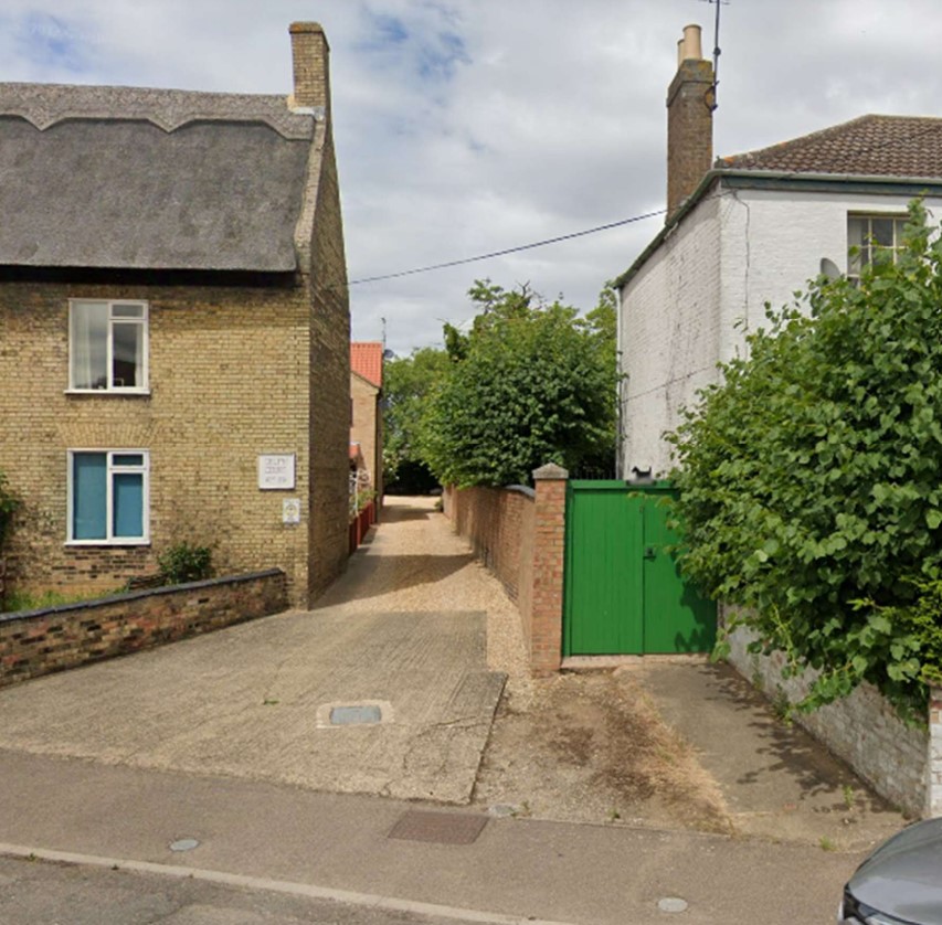 8 Delph Street Whittlesey Road between sites with modern development behind. Wall between the properties gives a clear divide, the Planning Inspectorate was told.