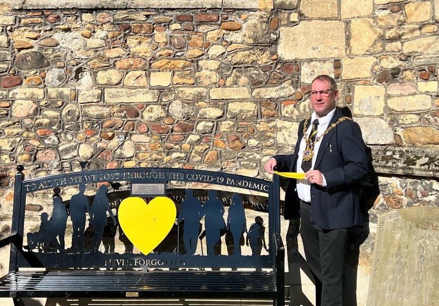 Mayor of Huntingdon Cllr Karl Brockett tying a ribbon around the bench